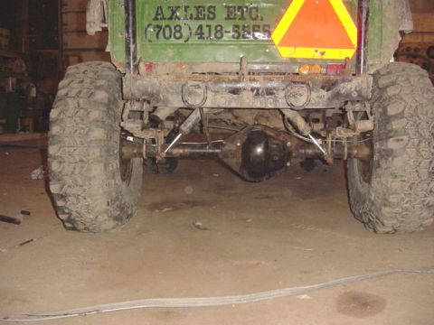 1992 Ford Bronco - The rear suspension and large tires of a green vehicle are visible, along with contact information for 'AXLES ETC.'.