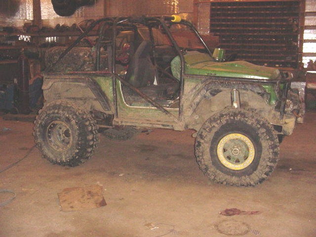 Green off-road SUV with roll cage and large tires