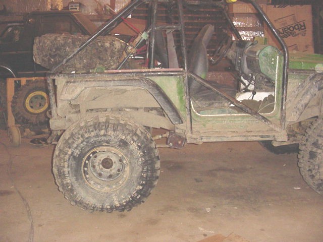 Modified off-road vehicle with roll cage, large tires, and exposed interior