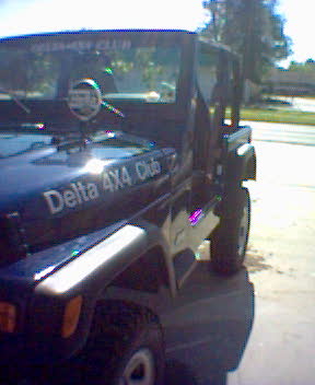 2002 Jeep Wrangler - A dark blue Jeep Wrangler is parked outdoors, showing "Delta 4x4 Club" on its hood.