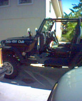 2002 Jeep Wrangler - A black Jeep Wrangler, identified as part of the "Delta 4x4 Club", is seen from the side.