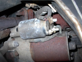 1996 Ford Crown Victoria - Close-up view of a vehicle's starter motor, showing wiring and surrounding engine components.