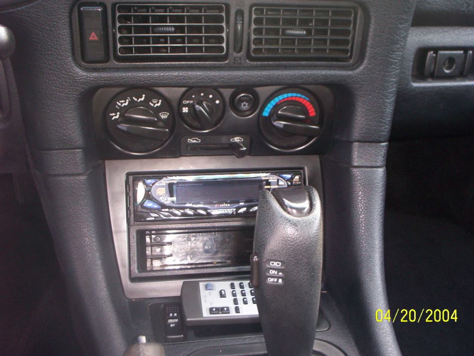 Center dash of a 3000GT with aftermarket CD head unit, HVAC dials, remote on console; dated 04/20/2004