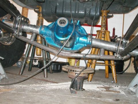 1994 Ford Bronco - Close-up view of a modified rear axle assembly, a bright blue differential housing and brake components.