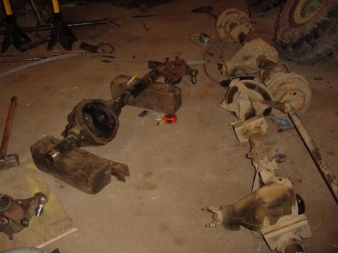 1992 Ford Bronco - Disassembled axles and suspension components are laid out on a workshop floor, suggesting a repair or modification project.
