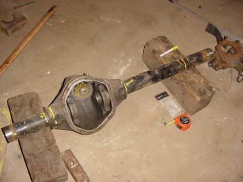 1992 Ford Bronco - Ford Dana 44 axle housing, differential cover removed, on blocks with tools.