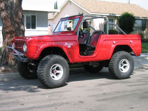 1969 Ford Bronco - This red 1969 Ford Bronco features a custom front bumper and a roll cage visible inside.