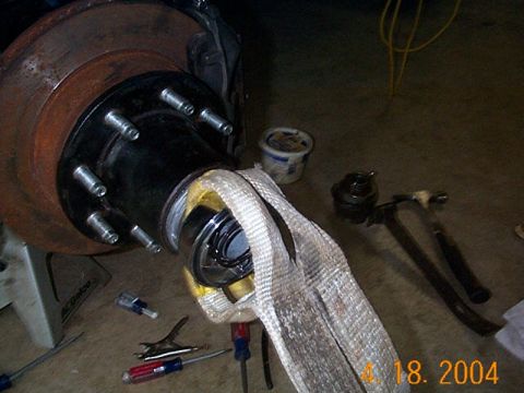 1986 Ford Bronco - Close-up of a vehicle's hub and rotor assembly, with tools nearby for maintenance.