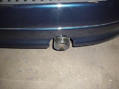 1993 Ford Taurus - Close-up of a dark blue car's rear bumper and exhaust pipe, with a Supermotors.com logo visible.