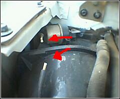 1992 Ford Bronco - Detail of an engine component, possibly a filter or housing, with directional indicators.