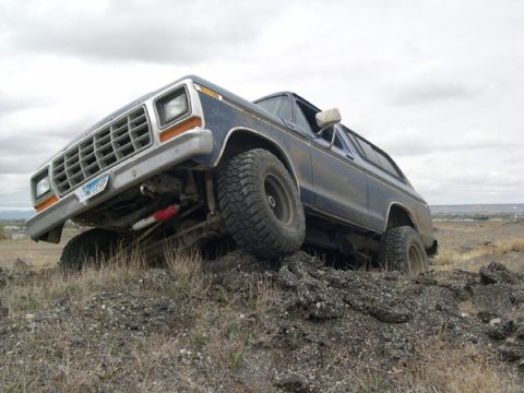 1978 Ford Bronco - Blue 1978 Ford Bronco navigating a rocky incline off-road.