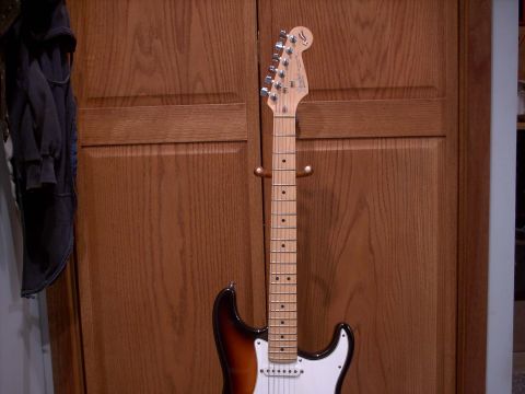 1986 Ford Bronco - Electric guitar with a sunburst finish and maple neck, mounted on a wooden stand.