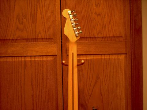 1986 Ford Bronco - The back of a guitar neck and headstock is shown against a backdrop of wood-paneled doors. The "SUPERMOTORS" logo is visible in the lower r…