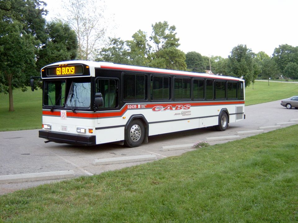 White CABS transit bus with GO BUCKS sign and red stripe parked on a campus drive