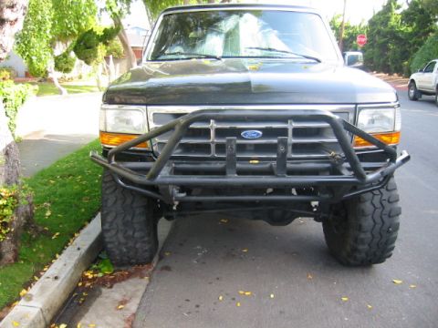 1992 Ford Bronco - This Ford Bronco features a custom front bumper and is parked curbside on a residential street.