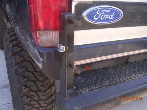 1994 Ford Bronco - Rear view of a 1994 Ford Bronco showing the bumper, tire, and Ford emblem.