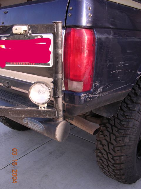 1994 Ford Bronco - The rear of an SUV shows a custom bumper with a spare tire mount and an aftermarket exhaust pipe. A date stamp is visible in the lower left…