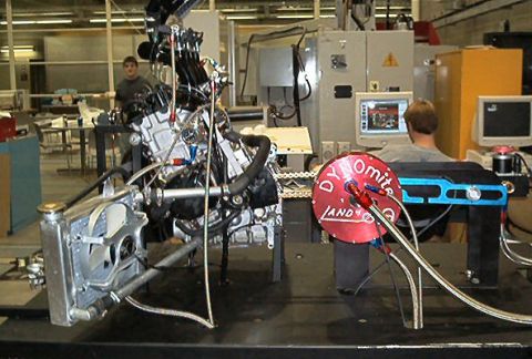 1985 Ford LTD Crown Victoria - An engine and radiator are set up on a dynamometer for testing in a workshop environment.