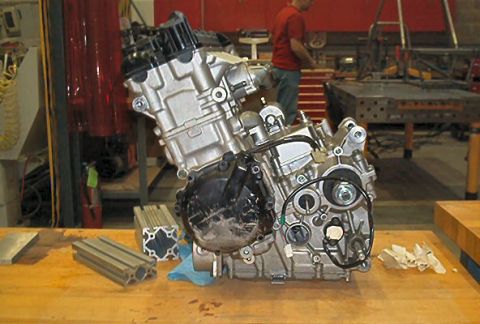 1985 Ford LTD Crown Victoria - Engine assembly resting on a wooden surface, with various metal components nearby.