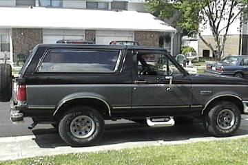 1989 Ford Bronco - This 1987 Ford Bronco is a two-tone black and gray SUV with a spare tire mounted on the back.