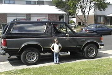 1989 Ford Bronco - This 1989 Ford Bronco is shown from the side with a young child standing next to it.