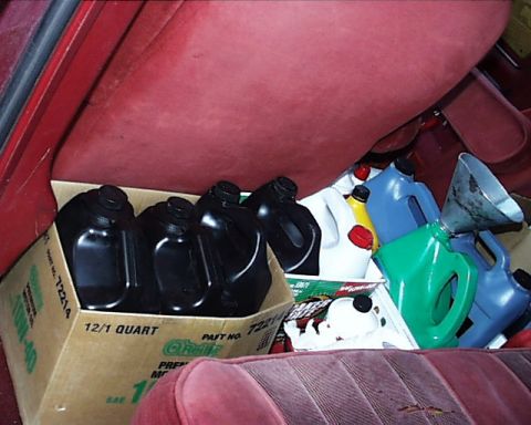 1988 Ford C-350 (Centurion Conversions) - Oil containers fill the interior of a vehicle, obscuring any specific model year details.