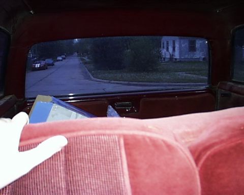 1988 Ford C-350 (Centurion Conversions) - View from the back seat of a 1988 Ford C-350 (Centurion Conversions) shows a residential street scene.
