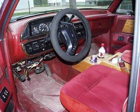 1988 Ford C-350 (Centurion Conversions) - The interior of this vehicle features red upholstery and wood trim accents on the dashboard and console.