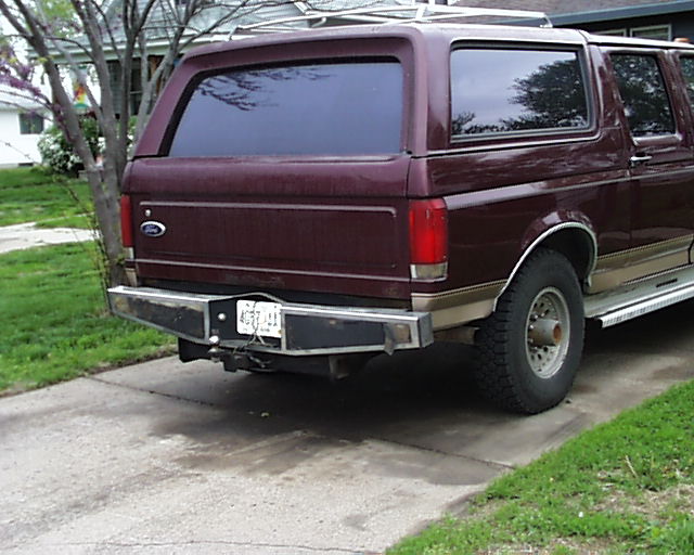 Maroon extended-roof Ford conversion wagon, rear three-quarter view in a driveway