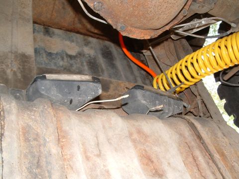1979 Ford Bronco - Underside view of rock lights and suspension components, with visible wiring and a coiled hose.