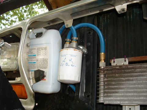 1979 Ford Bronco - Auxiliary fluid container and filter assembly mounted in the engine bay, connected to a cooling system component.