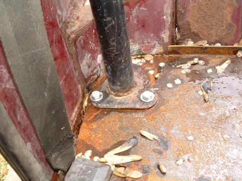 1979 Ford Bronco - The interior floor shows significant rust around the roll bar mounting point and a seatbelt anchor.