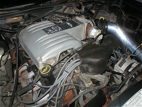 1987 Ford Crown Victoria LTD - Close-up view of a vehicle's engine bay, showing the intake manifold and associated components.