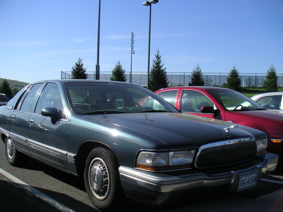 1994 Buick Roadmaster sedan, dark green, parked in a lot next to a red car. License plate JFG-6358