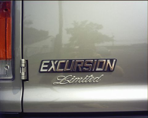 2003 Ford Excursion - The 'Excursion Limited' badge is visible on the rear of a silver SUV.