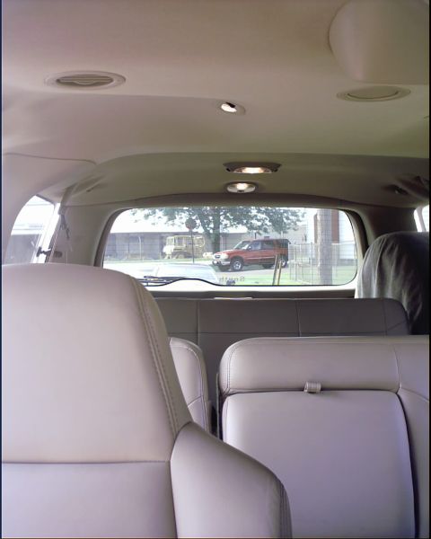 2003 Ford Excursion - View from the interior of a 2003 Ford Excursion, looking out the rear window at another SUV parked outside.
