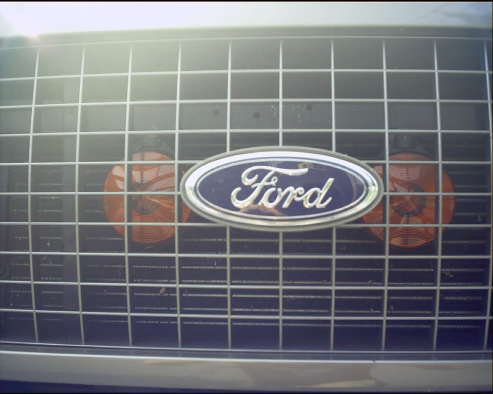 Ford oval emblem on chrome grille with amber lights on either side