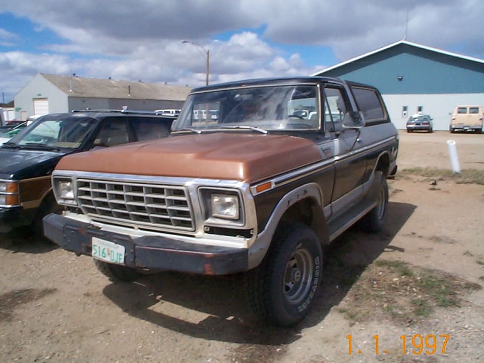 Two-tone brown 1979 Ford Bronco SUV parked in gravel lot, front three-quarter view