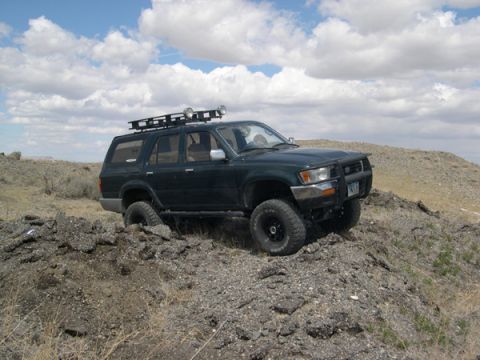 1978 Ford Bronco - This SUV is navigating a rough, rocky landscape under a partly cloudy sky.