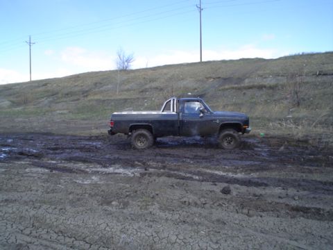 1981 Ford Bronco - This pickup truck is navigating through a very muddy and challenging off-road environment.