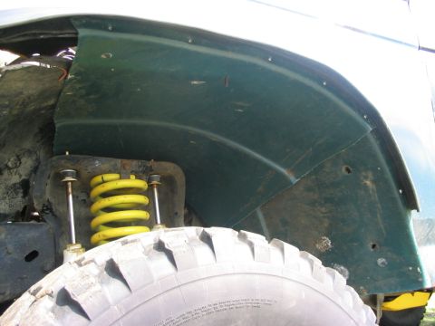 1986 Ford Bronco - Close-up of the wheelwell area of a 1986 Ford Bronco, showing the suspension and tire.
