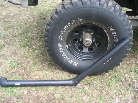1986 Ford Bronco - A close-up of a large tire and a snorkel accessory for an off-road vehicle.