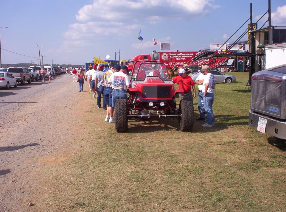 Red off-road vehicle with large tires and exposed suspension