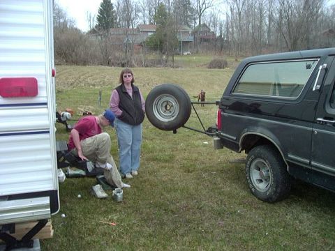 1992 Ford Bronco - Rear view of a black 1992 Ford Bronco, showing its spare tire carrier and a trailer.