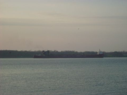 1992 Ford Bronco - A large cargo ship is seen on the water under a hazy sky.