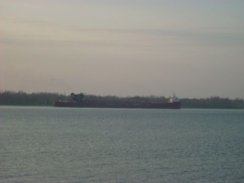1992 Ford Bronco - A large cargo ship is seen on the water under a hazy sky.