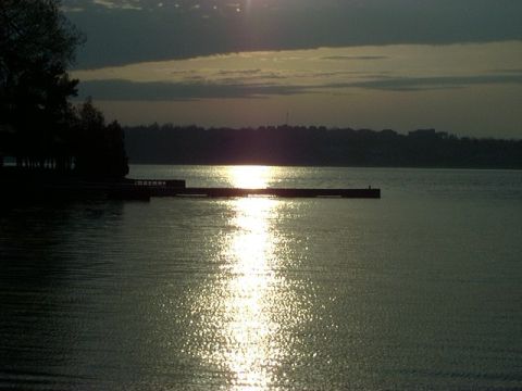 1992 Ford Bronco - A sunset scene over the water, with a pier extending into the lake and trees silhouetted on the left.