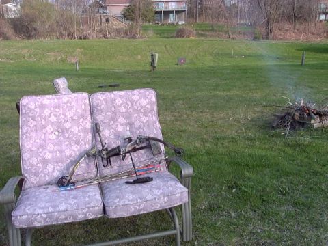 1992 Ford Bronco - Compound bow and arrows on a chair in a backyard setting with a campfire.