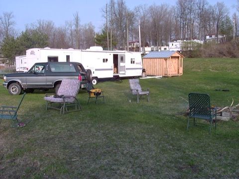 1992 Ford Bronco - This 1992 Ford Bronco is parked in a grassy area next to a large RV and a small wooden shed.