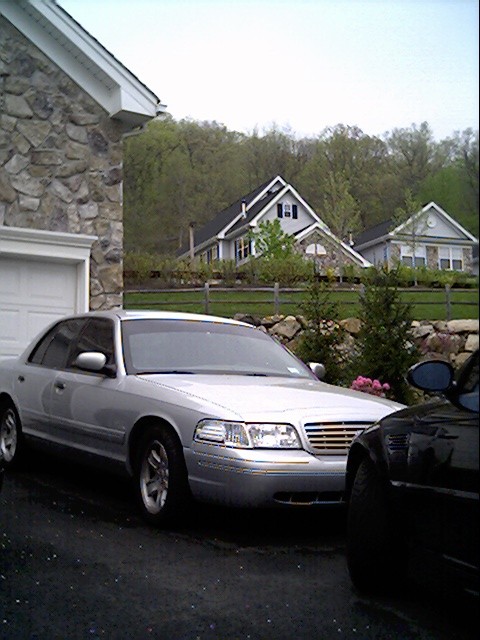 2002 Ford Crown Victoria - A 2002 Ford Crown Victoria is parked in front of a house with a stone garage.